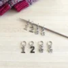 Marqueurs de mailles avec des numéros pour repérer vos aiguilles 1 et 2 quand vous tricotez des chaussettes, et des petites fleurs