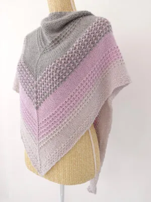 Châle au tricot avec de jolis points texturés, modèle Lila d'Aglaé Laser. Patron facile avec de la laine DK. Prenez vos aiguilles à tricoter et amusez-vous en tricotant Lila. Toutes les explications sont dans le patron avec photos et vidéos.